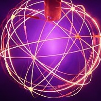 An image of the fusor, showing the glowing electromagnets and the light generated by excited neutrals